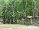 A black fence borders the backyard and has decorative flower boxes and mature trees at 168 Kennerly Center Dr, Mooresville, NC 28115