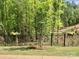 A black fence in the backyard has decorative flower boxes and mature trees at 168 Kennerly Center Dr, Mooresville, NC 28115