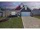 Charming home showcases a well-manicured lawn, stone accents, and a two-car garage at 168 Kennerly Center Dr, Mooresville, NC 28115