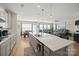 Open-concept kitchen with gray cabinets, quartz countertops, stainless steel appliances, and eat-in island at 168 Kennerly Center Dr, Mooresville, NC 28115