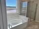 Modern bathroom showcasing a soaking tub and a glass-enclosed shower with a view at 1708 Honey Trl, Monroe, NC 28112