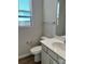 Elegant half bathroom featuring modern fixtures, a vanity, and a window with a view at 1708 Honey Trl, Monroe, NC 28112