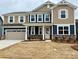 Charming two-story home featuring a two-car garage, stone accents, and a welcoming front porch at 1708 Honey Trl, Monroe, NC 28112