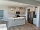 Bright kitchen features an island, stainless steel appliances, and stylish pendant lighting at 1708 Honey Trl, Monroe, NC 28112