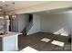 Open-concept living room with wood floors, seamlessly connecting to the kitchen and stairs at 1708 Honey Trl, Monroe, NC 28112
