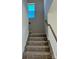 Carpeted stairway with white spindles and a wooden handrail, leading to the upper level at 1708 Honey Trl, Monroe, NC 28112