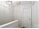 Upstairs hallway with white door, stairs, and a light fixture at 17537 Tuscany Ln, Cornelius, NC 28031