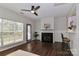 Bright living room featuring a fireplace, hardwood floors, a ceiling fan and breakfast bar into kitchen at 17537 Tuscany Ln, Cornelius, NC 28031