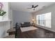 Bright living room with a ceiling fan, modern gray color palette and dark, wood-look floors at 17537 Tuscany Ln, Cornelius, NC 28031