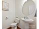 Stylish half bathroom with a pedestal sink, oval mirror, and modern fixtures at 181 Atwater Landing Dr, Mooresville, NC 28117