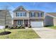 Inviting two-story home with a well-manicured lawn, stone accents, and a two car garage at 181 Atwater Landing Dr, Mooresville, NC 28117