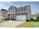 Two-story home boasts a stone facade, two-car garage, and well-manicured lawn at 181 Atwater Landing Dr, Mooresville, NC 28117