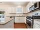 Bright, functional kitchen features white cabinets, stainless steel appliances, granite counters and hardwood floors at 181 Atwater Landing Dr, Mooresville, NC 28117