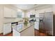 Well-lit kitchen features white cabinets, stainless steel appliances, granite countertops, and hardwood floors at 181 Atwater Landing Dr, Mooresville, NC 28117
