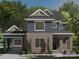 Charming two-story home featuring red brick, navy siding, and a welcoming covered porch at 19104 Newburg Hill Rd, Davidson, NC 28036