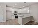 Modern kitchen featuring stainless appliances, white cabinets, and durable light wood flooring at 200 Lake George Dr, Shelby, NC 28152