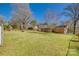 Expansive backyard with multiple utility sheds, a grassy lawn and playground at 2027 Franklin St, Rock Hill, SC 29732