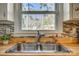Kitchen sink with stainless steel hardware, wood countertop, mosaic backsplash, and window view at 2027 Franklin St, Rock Hill, SC 29732