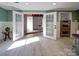 View of finished basement space, featuring tile floors, double doors, stainless oven, and green accent walls at 2036 Edgewater Dr, Charlotte, NC 28210