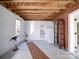 Open basement with exposed wood ceiling, neutral walls, and tile flooring, offering a versatile space at 2036 Edgewater Dr, Charlotte, NC 28210