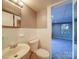 Bright bathroom featuring a sink, toilet, and tile accents, seamlessly connecting to an adjacent carpeted room at 2036 Edgewater Dr, Charlotte, NC 28210