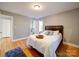 Bedroom with light wood floors, gray walls, a walk-in closet, and an attached bathroom at 2036 Edgewater Dr, Charlotte, NC 28210