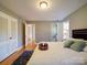 This spacious bedroom features wood floors, light gray walls, and a view into the bathroom at 2036 Edgewater Dr, Charlotte, NC 28210