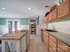 View of kitchen with stainless double oven, kitchen island with bar seating, and wood cabinets at 2036 Edgewater Dr, Charlotte, NC 28210