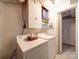 Functional laundry room featuring essential appliances, storage shelves, and an open doorway at 2036 Edgewater Dr, Charlotte, NC 28210