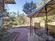 Tranquil backyard patio with brick pavers, an umbrella-covered table, and lush greenery, perfect for outdoor lounging at 2036 Edgewater Dr, Charlotte, NC 28210