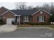 Inviting brick home with an attached one-car garage, complemented by well-maintained landscaping and an attractive front entrance at 2207 Windsor Woods Dr, Gastonia, NC 28054