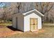 A small storage shed with double doors sits on the back lawn at 2509 Wesley Chapel Rd, Indian Trail, NC 28079