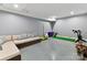 Spacious basement featuring gray epoxy flooring, lounge area, exercise equipment, and ample room for activities at 3416 Windsor Dr, Charlotte, NC 28209