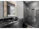Modern bathroom featuring a dark vanity, black fixtures, and a tiled glass-enclosed shower at 3416 Windsor Dr, Charlotte, NC 28209