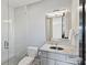 Bathroom with tiled shower with glass door, toilet, vanity with solid surface counter and rectangular mirror with accent lighting at 3416 Windsor Dr, Charlotte, NC 28209