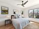 Bedroom featuring light hardwood floors, a large bed with multiple pillows, nightstands, and views to the outside at 3416 Windsor Dr, Charlotte, NC 28209