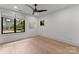 Stylish bedroom with wood floors, large windows offering scenic views, and patterned accent wall at 3416 Windsor Dr, Charlotte, NC 28209
