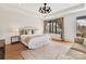 Bright bedroom features a cozy seating area, elegant chandelier, and large window with pleasant outdoor views at 3416 Windsor Dr, Charlotte, NC 28209