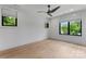 Bright bedroom with wood floors, natural light from large windows, and a contemporary ceiling fan at 3416 Windsor Dr, Charlotte, NC 28209