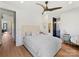 Bedroom featuring light hardwood floors, a large bed with a tufted headboard, nightstands, and views into an ensuite bathroom at 3416 Windsor Dr, Charlotte, NC 28209