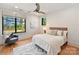 Bright bedroom with textured wallpaper, two large windows, ceiling fan and comfortable chair on hardwood floors at 3416 Windsor Dr, Charlotte, NC 28209