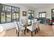 Dining room features a glass-top table, six chairs, black framed windows, and access to the backyard at 3416 Windsor Dr, Charlotte, NC 28209