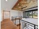 Bright second floor hallway with wood ceiling, hardwood floors, metal railings and access to other rooms at 3416 Windsor Dr, Charlotte, NC 28209