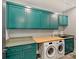 Functional laundry room featuring built-in cabinets, counter space, a utility sink, and modern washer and dryer units at 3416 Windsor Dr, Charlotte, NC 28209