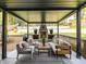 Covered outdoor patio featuring lounge seating, a stone fireplace, landscaping, and an outdoor rug at 3416 Windsor Dr, Charlotte, NC 28209