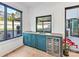 This wet bar features a built-in wine cooler, sink, faucet, and blue cabinets under a window at 3416 Windsor Dr, Charlotte, NC 28209