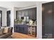 Stylish wet bar with custom cabinets, a wine cooler, and modern fixtures at 3416 Windsor Dr, Charlotte, NC 28209
