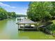 Covered boat dock with access steps, surrounded by lush greenery and tranquil water at 406 Morrison Farm Rd, Troutman, NC 28166