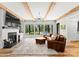 Cozy living room with a brick fireplace, wood beams, and large windows offering backyard views at 406 Morrison Farm Rd, Troutman, NC 28166