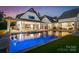 Evening view of the pool and outdoor entertainment area with lighted pool and spa at 406 Morrison Farm Rd, Troutman, NC 28166